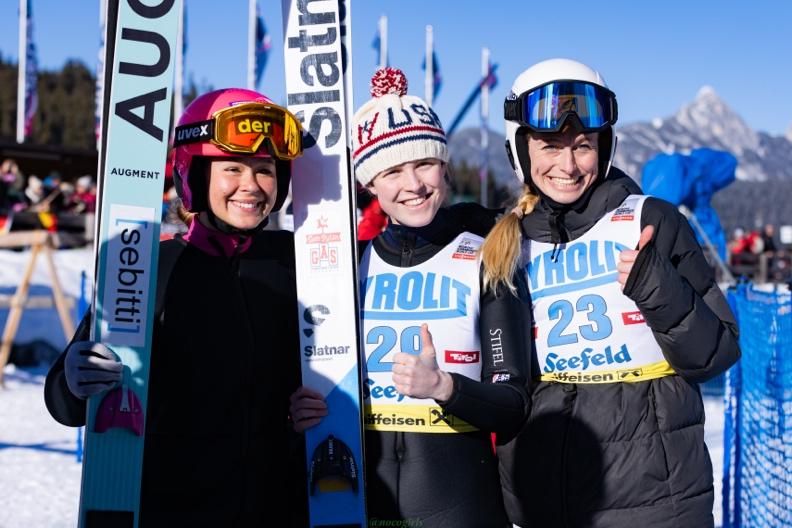 Women Nordic Combined athletes with skis and poles
