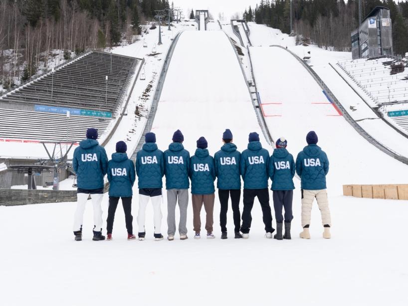Nordic Combined athletes lined up near a ski jump
